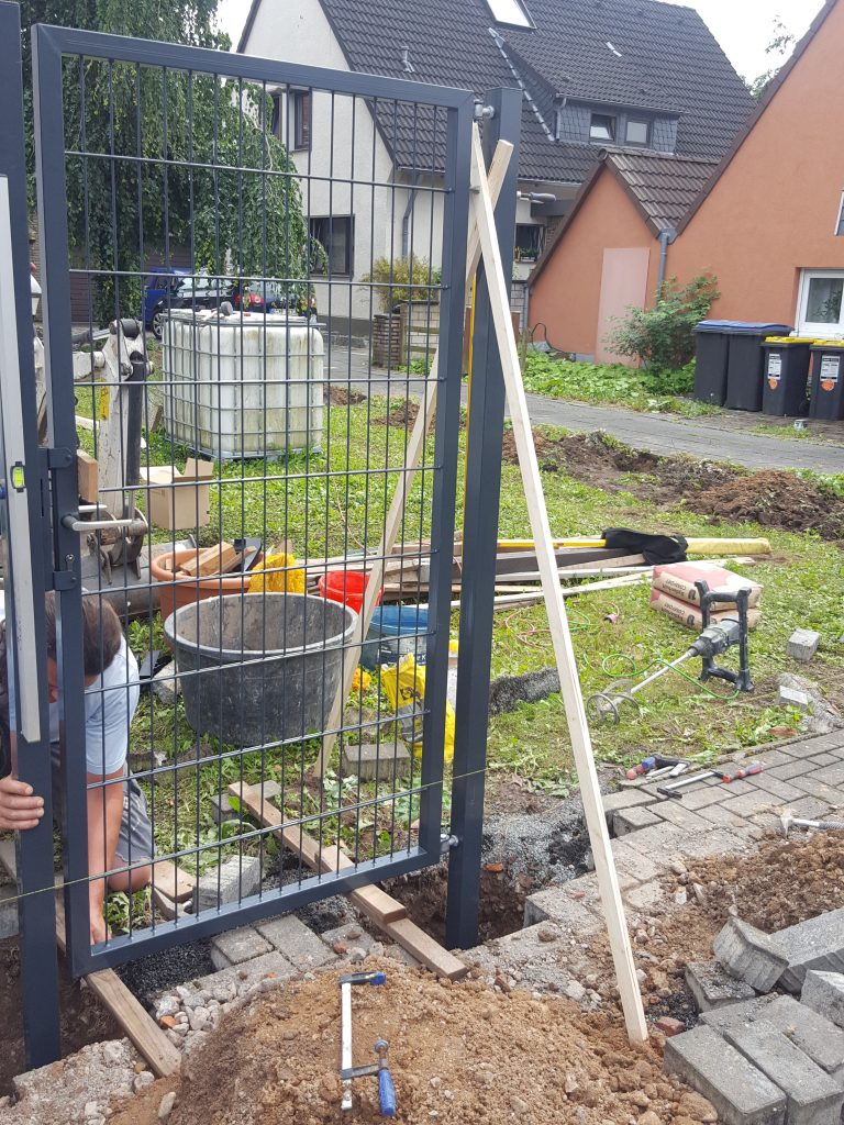 Montage eines Gartentors und Zaunpfostens – Zaunbau und Außenanlagen in Köln
