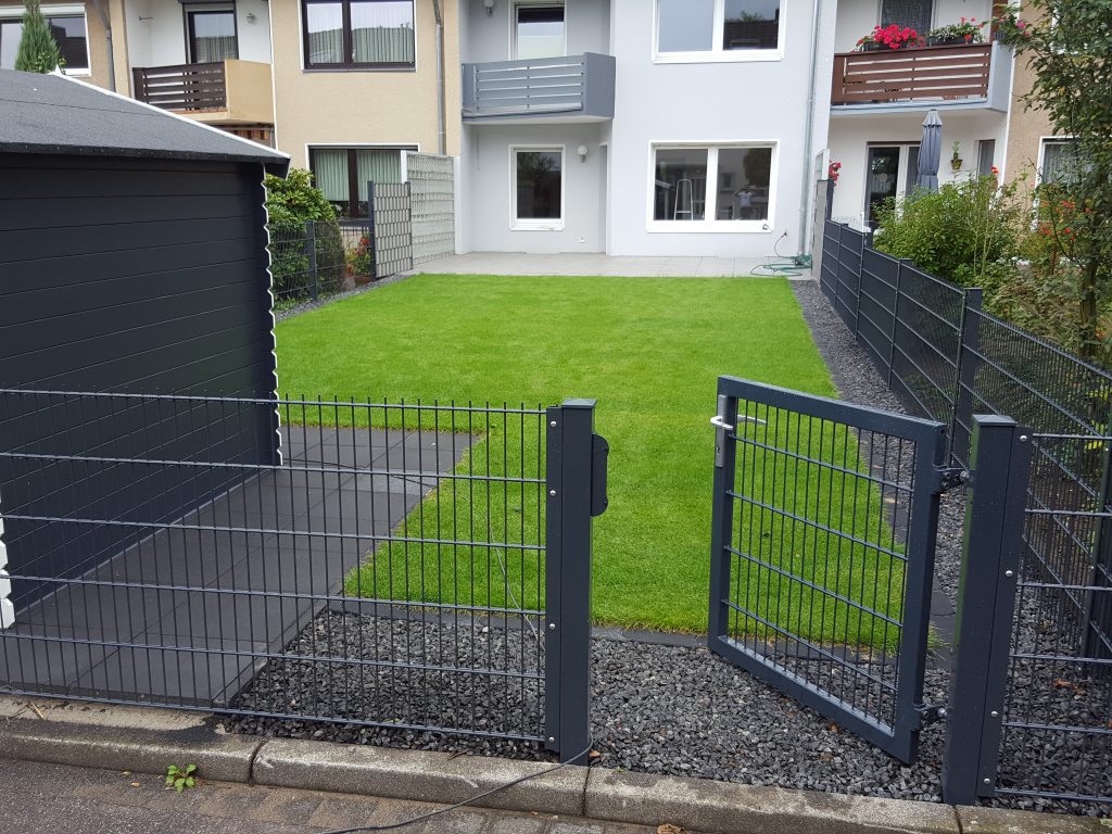 Außenanlagen mit Terrasse, Rasenmähkante, Zaun und Gartentor – Garten- und Terrassenbau in Köln
